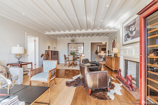 living room featuring beam ceiling, hardwood / wood-style floors, and a high end fireplace