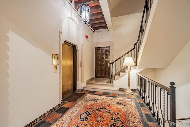 foyer with a towering ceiling and beamed ceiling