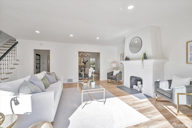 living room with an inviting chandelier and light hardwood / wood-style floors