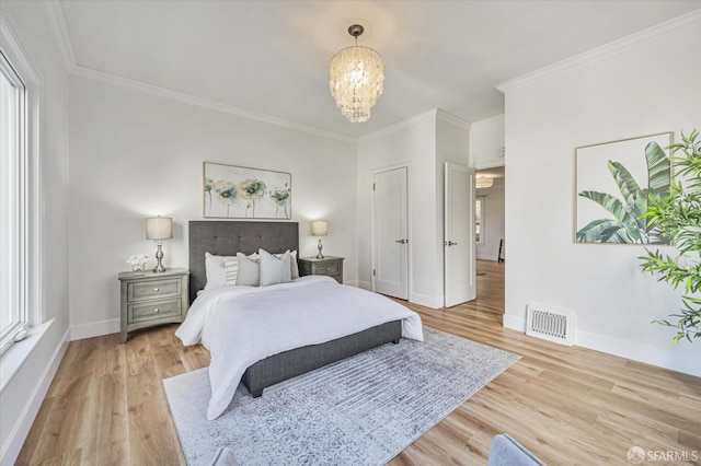 bedroom featuring crown molding, a notable chandelier, and light hardwood / wood-style flooring