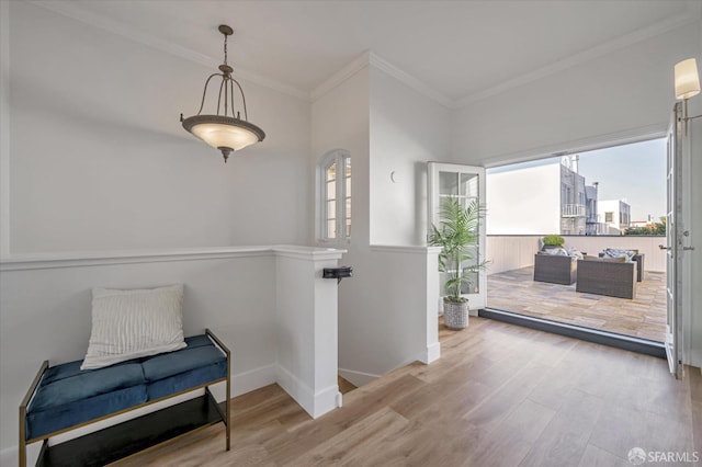 sitting room featuring ornamental molding and light wood-type flooring