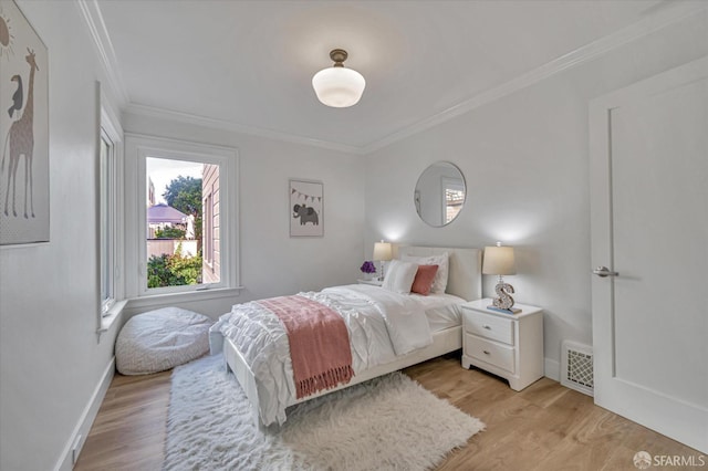 bedroom with light hardwood / wood-style flooring and ornamental molding