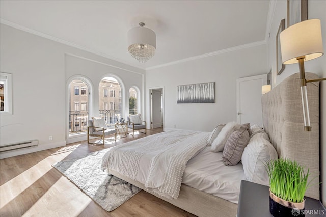 bedroom featuring crown molding, a baseboard heating unit, and light hardwood / wood-style floors