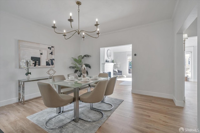 dining area with crown molding, plenty of natural light, a chandelier, and light wood-type flooring