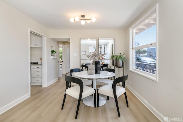 dining space with light wood-style floors and baseboards