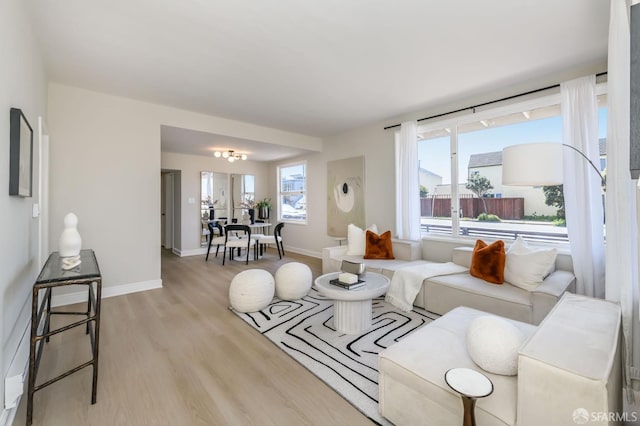 living area featuring baseboards and light wood-type flooring