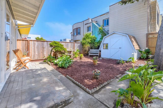 view of yard with a storage unit, a fenced backyard, a patio area, and an outbuilding