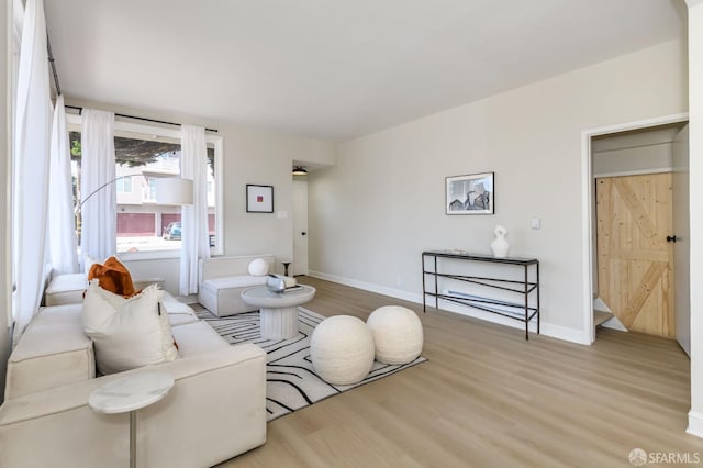 living area with baseboards and wood finished floors