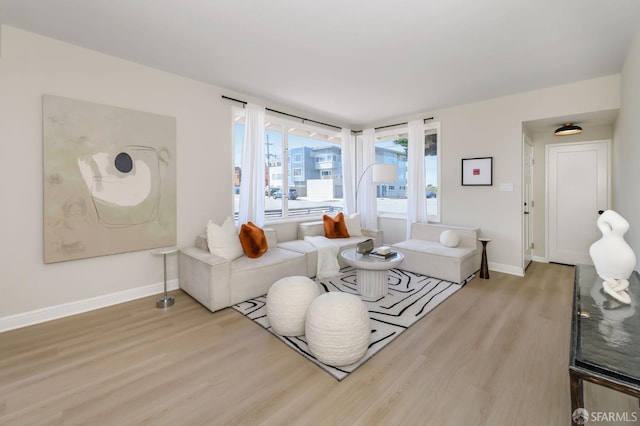 living area with baseboards and wood finished floors