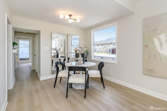 dining space with baseboards and light wood finished floors