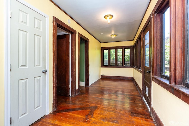 hallway with baseboards, ornamental molding, and hardwood / wood-style floors