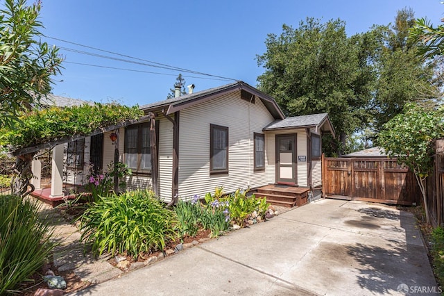 bungalow featuring fence and driveway