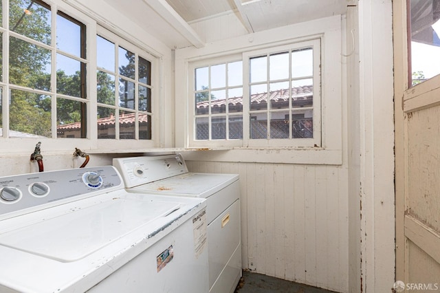 laundry area featuring laundry area, wooden walls, and washer and dryer