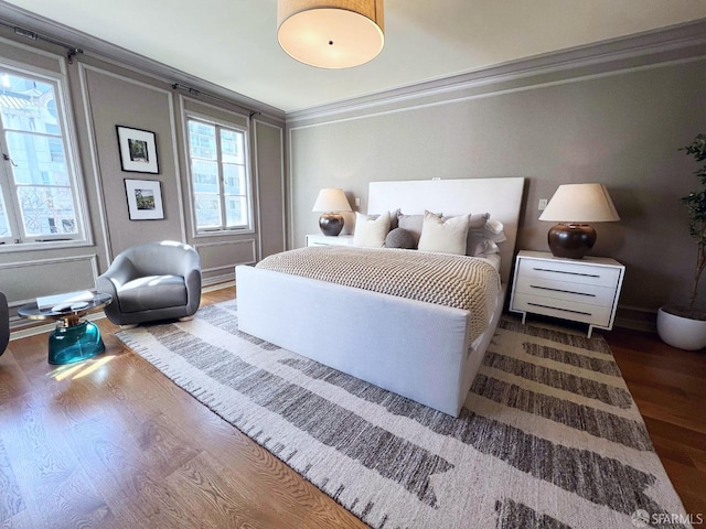 bedroom featuring crown molding and wood finished floors