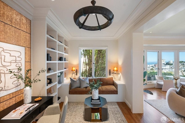 living area with crown molding and wood finished floors