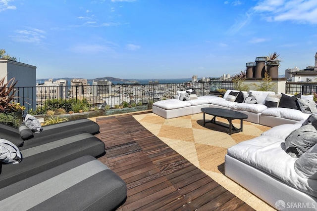 wooden deck with a view of city and outdoor lounge area