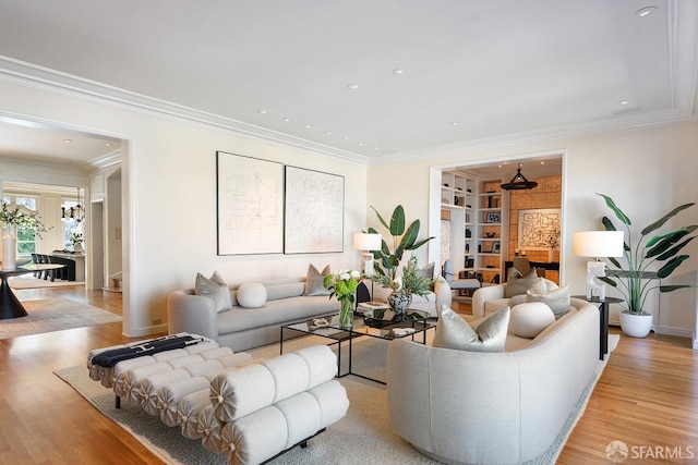living area with built in features, recessed lighting, light wood finished floors, and ornamental molding
