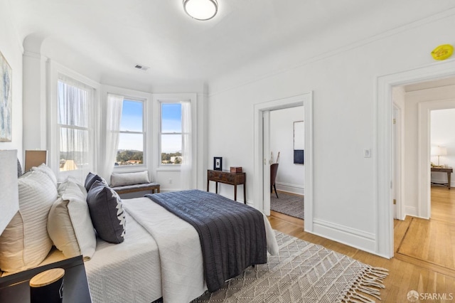 1015 Ashbury St Unit 4, San Francisco, CA 94117 - bedroom with multiple windows, light wood-style flooring, and connected bathroom