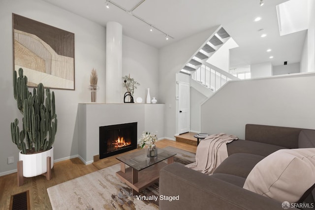 120 Landers St Unit D, San Francisco, CA 94114 - living area featuring wood finished floors, a lit fireplace, baseboards, rail lighting, and recessed lighting