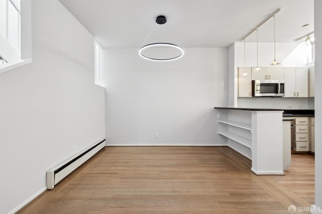 120 Landers St Unit D, San Francisco, CA 94114 - unfurnished dining area featuring a baseboard heating unit, light wood-style floors, and baseboards