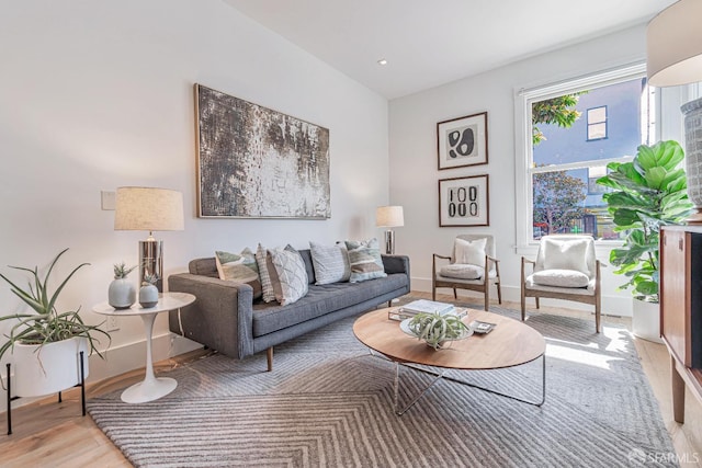 living room featuring recessed lighting, baseboards, and light wood finished floors