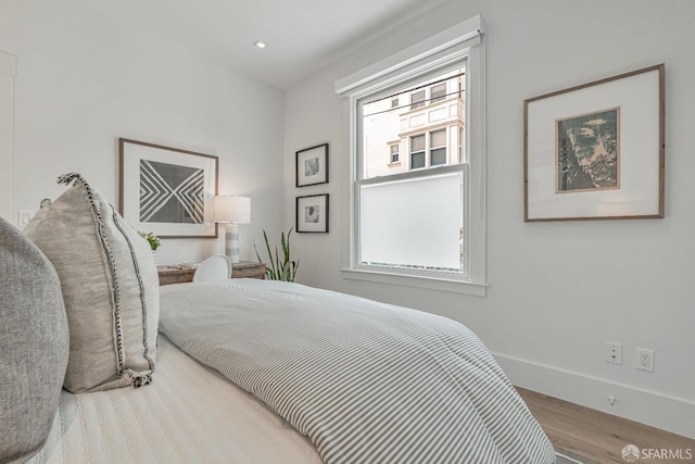 bedroom with recessed lighting, baseboards, and wood finished floors