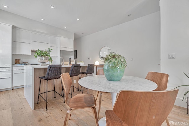 dining space featuring light wood finished floors and recessed lighting