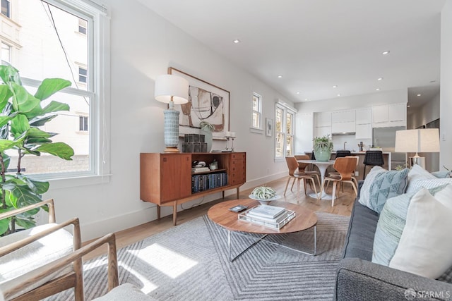 living area with recessed lighting, light wood-type flooring, and baseboards