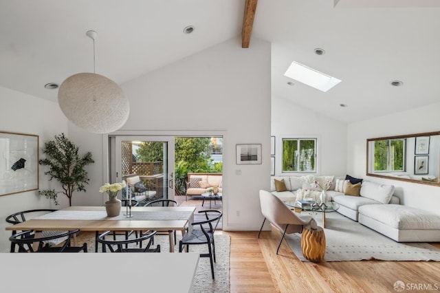 living room with beam ceiling, a skylight, high vaulted ceiling, and light wood-type flooring