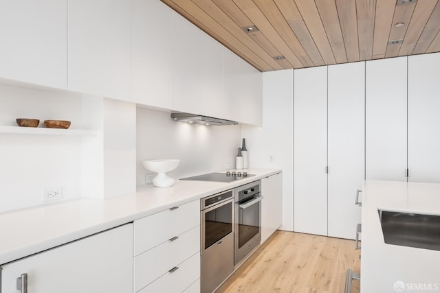 38 Bryant St Unit 405, San Francisco, CA 94105 - kitchen featuring stainless steel oven, black electric cooktop, open shelves, modern cabinets, and light countertops