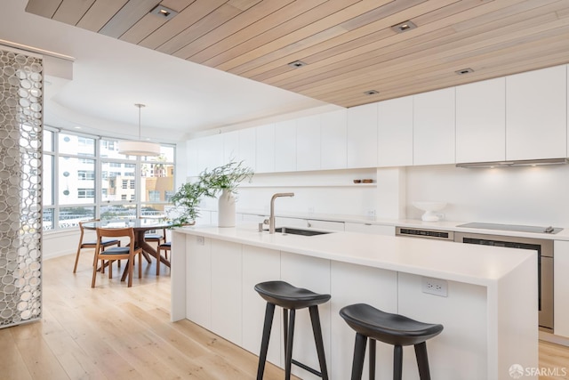 38 Bryant St Unit 405, San Francisco, CA 94105 - kitchen featuring a sink, light wood finished floors, light countertops, and white cabinets