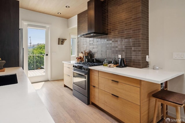 1515 Van Dyke Ave, San Francisco, CA 94124 - kitchen with stainless steel gas stove, wall chimney range hood, modern cabinets, decorative backsplash, and light wood-type flooring