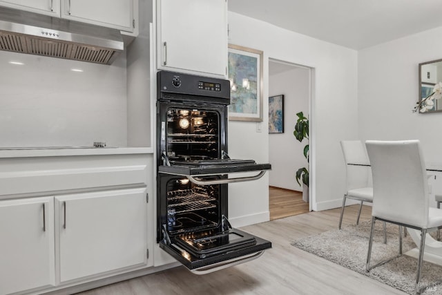 7 Hearthstone Ct, San Rafael, CA 94903 - kitchen featuring under cabinet range hood, black oven, white cabinets, light wood finished floors, and light countertops