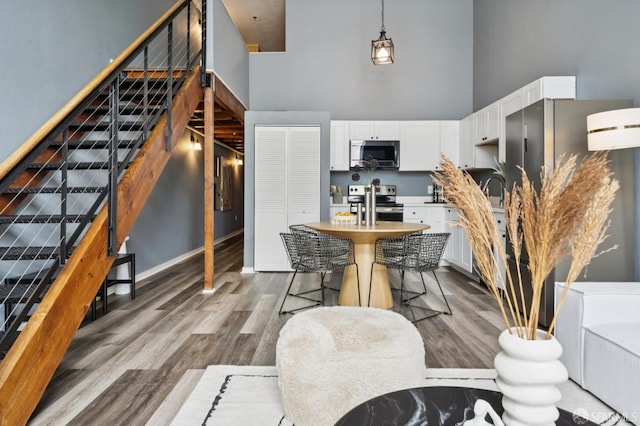 175 Bluxome St Unit 202, San Francisco, CA 94107 - dining room with a high ceiling, stairs, and wood finished floors