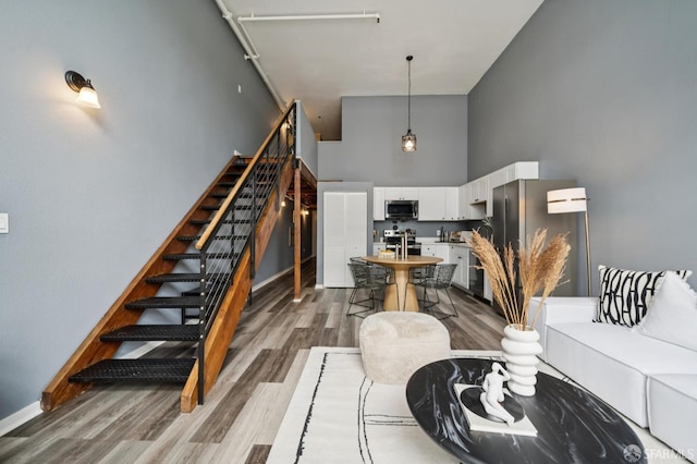 175 Bluxome St Unit 202, San Francisco, CA 94107 - living area featuring a towering ceiling, wood finished floors, and stairway