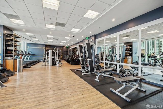 workout area featuring a drop ceiling and wood finished floors