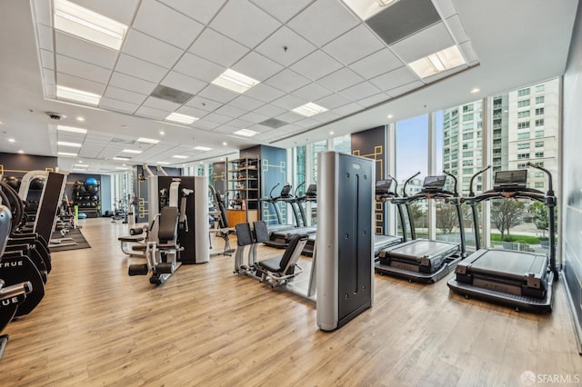 workout area featuring floor to ceiling windows and wood finished floors