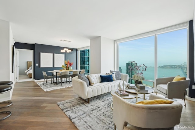living area featuring an inviting chandelier, wood finished floors, and a healthy amount of sunlight