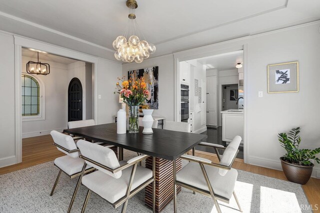 1998 Vallejo St Unit 2, San Francisco, CA 94123 - dining room with a chandelier, light wood finished floors, and arched walkways