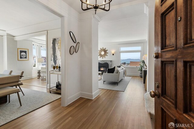 1998 Vallejo St Unit 2, San Francisco, CA 94123 - foyer featuring plenty of natural light, a warm lit fireplace, light wood-style floors, and ornamental molding