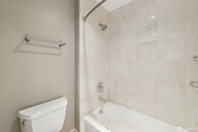 bathroom featuring toilet and tiled shower / bath