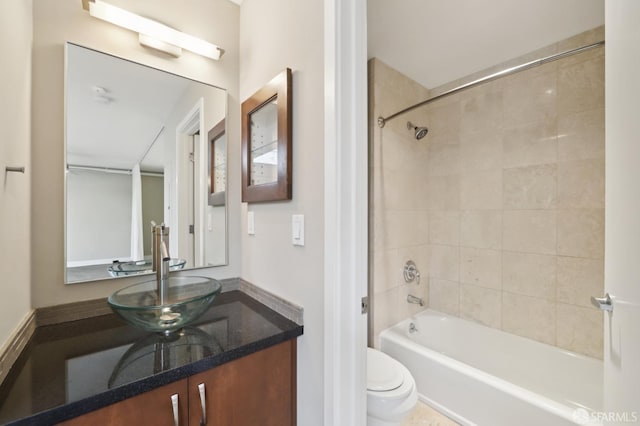 full bathroom featuring tiled shower / bath, vanity, and toilet