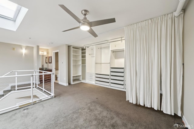 carpeted spare room with ceiling fan and a skylight