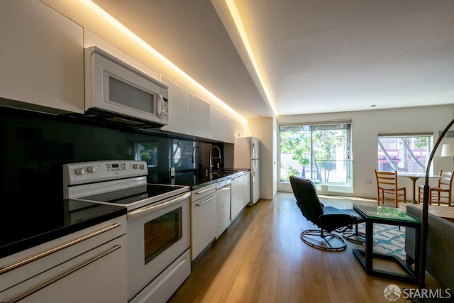 2000 Ellis St Unit 201, San Francisco, CA 94115 - kitchen with white appliances, white cabinets, dark countertops, and light wood-style flooring