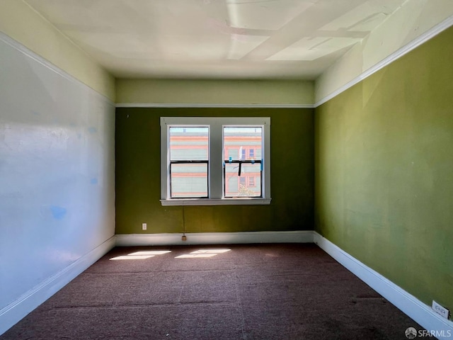 empty room featuring carpet and baseboards