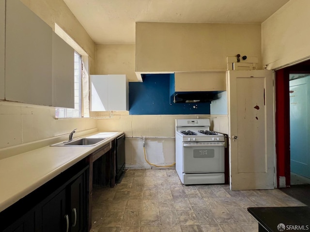 kitchen with white gas range, a sink, under cabinet range hood, light countertops, and black dishwasher