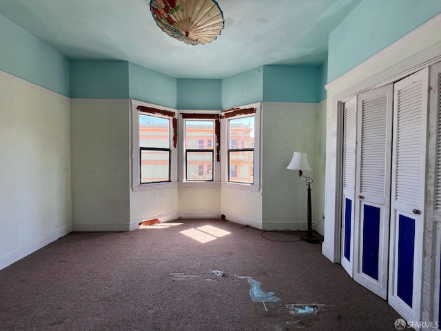 unfurnished bedroom with carpet, a closet, and baseboards