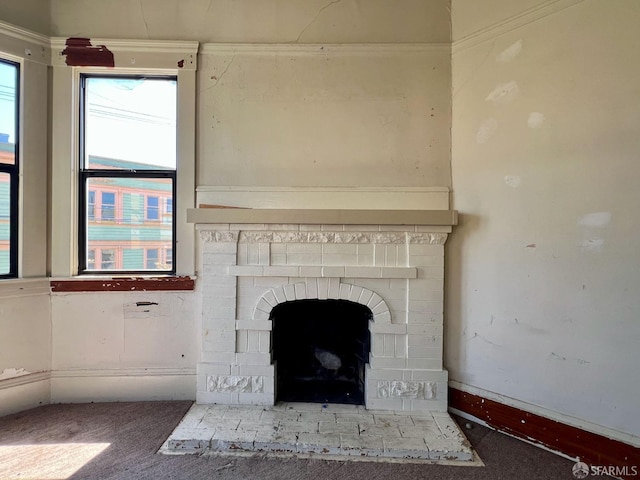 detailed view of a brick fireplace, carpet flooring, and baseboards
