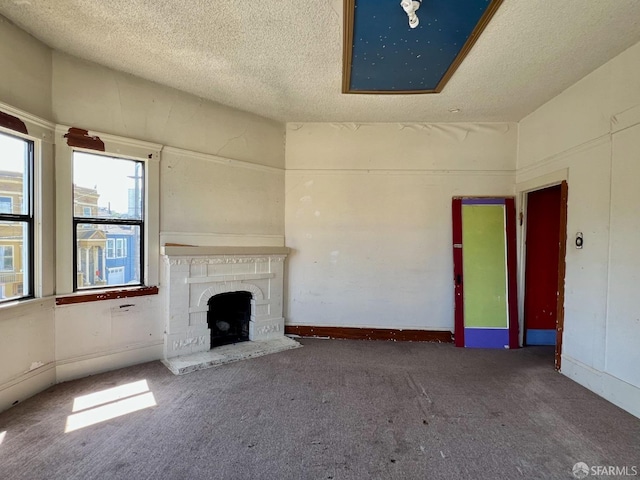 unfurnished living room with carpet, a textured ceiling, and a fireplace