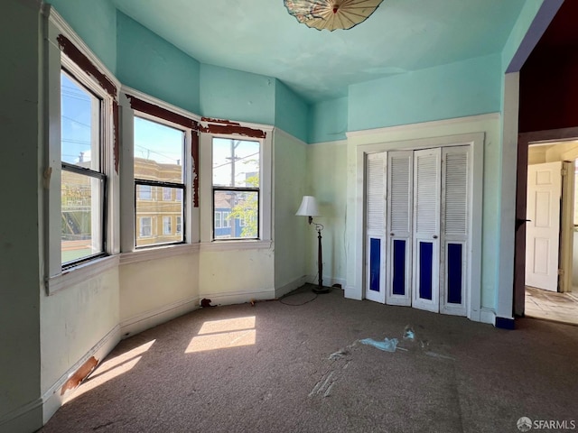 unfurnished bedroom featuring carpet, a closet, and baseboards